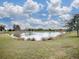 Community lake view with grassy areas and mature trees at 5911 Delphina Loop, The Villages, FL 32163