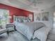 Main bedroom with king-size bed, red accent wall, and stylish decor at 5911 Delphina Loop, The Villages, FL 32163