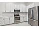 Modern kitchen with stainless steel appliances and white cabinets at 10173 Lake Miona Way, Oxford, FL 34484