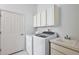 Bright laundry room with washer, dryer, and cabinets at 10173 Lake Miona Way, Oxford, FL 34484