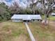 Aerial view of a ranch style home with a metal roof and a walkway leading to the front entrance at 1029 Cr 452A, Lake Panasoffkee, FL 33538