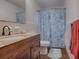 Bathroom has granite countertop, wood vanity, and blue seashell shower curtain at 1029 Cr 452A, Lake Panasoffkee, FL 33538