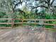 Wooden deck with metal table and chairs, overlooking a lush backyard with trees at 1029 Cr 452A, Lake Panasoffkee, FL 33538