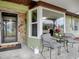 Front porch with a stone accent wall, and black metal chairs at 1029 Cr 452A, Lake Panasoffkee, FL 33538