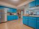 View of kitchen with blue cabinets, stainless steel appliances and wood laminate flooring at 1029 Cr 452A, Lake Panasoffkee, FL 33538