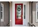 Inviting red front door with glass accents and wreath at 10377 Silver Maple Ave, Oxford, FL 34484