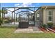 Brick paved patio area with built-in grill and screened enclosure at 10377 Silver Maple Ave, Oxford, FL 34484