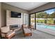 Relaxing poolside patio with fireplace and sliding glass doors at 10377 Silver Maple Ave, Oxford, FL 34484