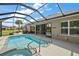 Inviting screened pool and spa with spacious patio and lush landscaping at 10377 Silver Maple Ave, Oxford, FL 34484