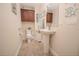 Clean bathroom with pedestal sink and tiled floors at 11189 Roz Way, Oxford, FL 34484