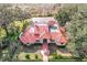 Aerial view of a luxurious home with red tile roof, pool, and lush landscaping at 1130 Elysium Blvd, Mount Dora, FL 32757