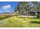 Landscaped backyard with lush greenery and a screened enclosure at 1130 Elysium Blvd, Mount Dora, FL 32757