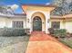 Elegant house entrance with arched doorway and terracotta tile walkway at 1130 Elysium Blvd, Mount Dora, FL 32757