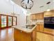 Kitchen boasts an island, wood cabinets, and French doors leading to a patio at 1130 Elysium Blvd, Mount Dora, FL 32757