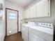 Laundry room with washer, dryer, cabinets, and exterior access at 1130 Elysium Blvd, Mount Dora, FL 32757