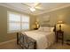 Bright bedroom with a comfortable bed, nightstands, and window shutters at 1189 Homeland Park St, The Villages, FL 32162