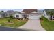 Front view of house with landscaped yard and paved driveway at 1216 Addison Ave, The Villages, FL 32162