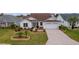 Front view of house with landscaped yard and paved driveway at 1216 Addison Ave, The Villages, FL 32162