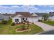 Front view of house with landscaped yard and paved driveway at 1216 Addison Ave, The Villages, FL 32162