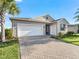 One-story home with gray siding, white garage door, and landscaped yard at 12213 Se 176Th Loop, Summerfield, FL 34491