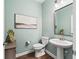 Modern powder room with pedestal sink, toilet, and wood-look floors at 12213 Se 176Th Loop, Summerfield, FL 34491