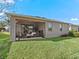 Relaxing screened lanai with paver patio, wicker furniture, and lush landscaping at 12213 Se 176Th Loop, Summerfield, FL 34491