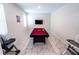 A game room provides entertainment with a pool table, TV, and modern tiled floors at 1257 Challenge Dr, Davenport, FL 33896