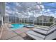A private screened-in pool with lounge chairs offers a relaxing outdoor retreat at 1257 Challenge Dr, Davenport, FL 33896