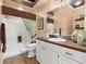 Well-lit bathroom with tile flooring, a wide mirror, and a tiled shower area at 1276 Bennett Pl, The Villages, FL 32162