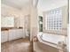 Elegant bathroom with a soaking tub, and a large window, offering a spa-like experience at 1276 Bennett Pl, The Villages, FL 32162