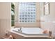 Bathroom with corner bathtub, glass block window, and tiled walls at 1276 Bennett Pl, The Villages, FL 32162