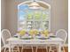 Bright dining area featuring a window with plantation shutters, decorated with a beautifully set table at 1276 Bennett Pl, The Villages, FL 32162