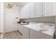 Laundry room with white cabinets, washer, dryer, and utility sink at 1276 Bennett Pl, The Villages, FL 32162