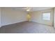 Spacious carpeted bedroom with window and ceiling fan at 1350 Cavender Creek Rd, Minneola, FL 34715