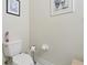 Neutral powder room featuring a toilet, wall art, and functional accessories at 13718 County Road 450, Umatilla, FL 32784