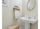 Charming powder room with pedestal sink, decorative mirror, and a neutral color palette at 13718 County Road 450, Umatilla, FL 32784