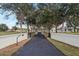 Long driveway leading to a charming home with a gated entrance at 13718 County Road 450, Umatilla, FL 32784