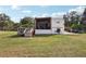 Exterior view of RV with wooden deck and railings in a grassy outdoor setting at 13718 County Road 450, Umatilla, FL 32784