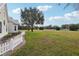 A large grassy yard with a white picket fence near the home at 13718 County Road 450, Umatilla, FL 32784