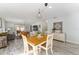 Bright dining area with a light wood table and white chairs, adjacent to living room at 1410 Conchas Dr, The Villages, FL 32162