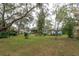 Landscaped backyard with mature trees and house view at 1420 Anderson St, Clermont, FL 34711