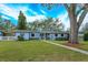 Cute light blue house with a spacious yard, walkway, and large tree at 1420 Anderson St, Clermont, FL 34711