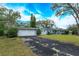 Two-car garage with long driveway and mature landscaping at 1420 Anderson St, Clermont, FL 34711