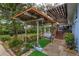 Covered patio with wooden pergola, seating, and lush greenery at 1420 Anderson St, Clermont, FL 34711