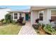 Front entrance with teal door and landscaping at 1548 Loris Loop, The Villages, FL 32162