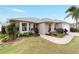 Charming single-story home featuring a well-manicured lawn and a lovely stone walkway at 1548 Loris Loop, The Villages, FL 32162