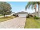 Charming curb appeal with paver driveway and lush landscaping at 1548 Loris Loop, The Villages, FL 32162