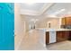 Kitchen with light beige cabinets and view into living room at 1548 Loris Loop, The Villages, FL 32162