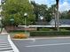 Community entrance with brick wall, manicured hedges, and colorful flower bed at 1562 Lawndale Cir, Winter Park, FL 32792