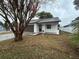 Newly renovated home with white exterior, brown garage door, and landscaped yard at 1562 Lawndale Cir, Winter Park, FL 32792